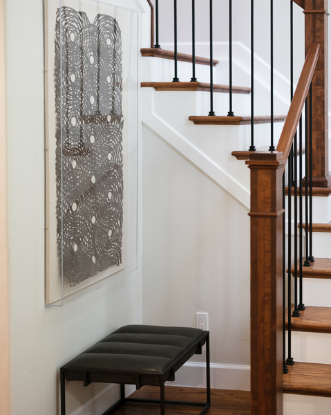 <img src="artandframing_ourshoppage.png" alt="Black rice paper art in acrylic frame above black leather bench in stairwell">