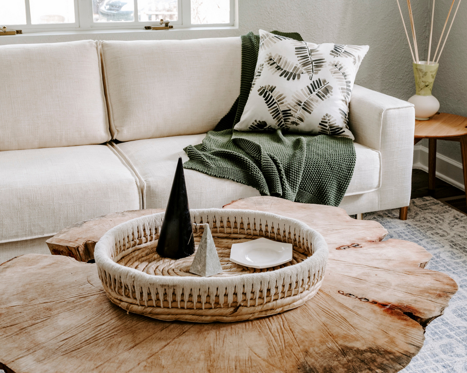 <img src="livingroomwithwhitesofaandliveedgecoffeetable_projects.png" alt="Living room with white sofa, green throw blanket, black and white palm pillow, and live edge coffee table with decorative accents">